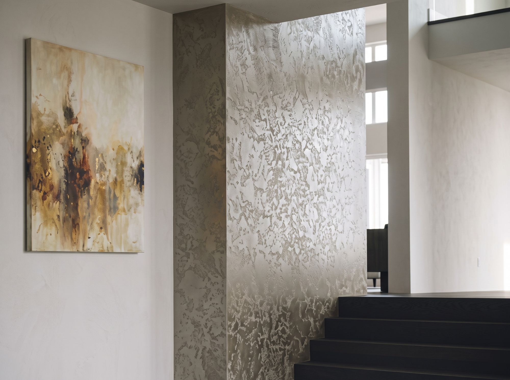 Champagne metallic plaster stairwell column beside dark oak stairs in a Branson residence
